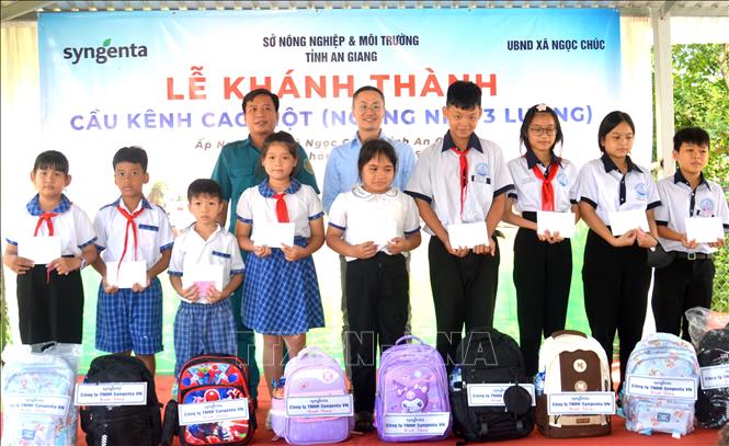 Ban tổ chức trao quà cho học sinh vượt khó học tốt. Ảnh: Văn Sĩ - TTXVN