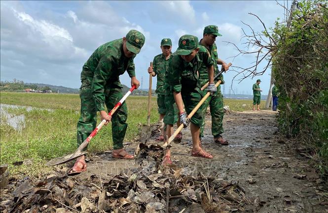 Cán bộ, chiến sỹ Đồn Biên Phòng Tuy Hòa dọn bùn đất tại phường Phú Yên để người dân đi lại thuận tiện. Ảnh: Tường Quân - TTXVN