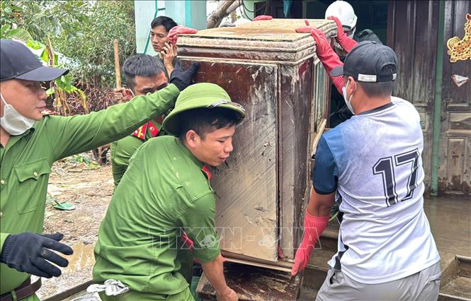 Cán bộ, chiến sỹ Công an tỉnh Đắk Lắk giúp người dân dọn dẹp đồ đạc bị hư hỏng do mưa lũ. Ảnh: Tường Quân - TTXVN
