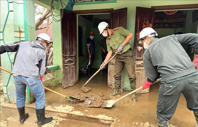 Lực lượng Công an tỉnh Đắk Lắk giúp người dân vùng lũ dọn dẹp nhà cửa. Ảnh: Tường Quân - TTXVN