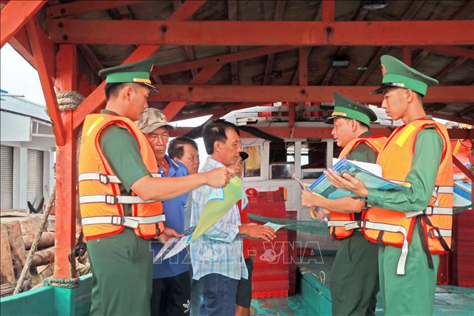 Cán bộ, chiến sĩ Trạm kiểm soát Biên phòng Sông Đốc thường xuyên tuyên truyền, phổ biến các quy định về phòng chống IUU cho ngư dân. Ảnh: Huỳnh Anh - TTXVN 