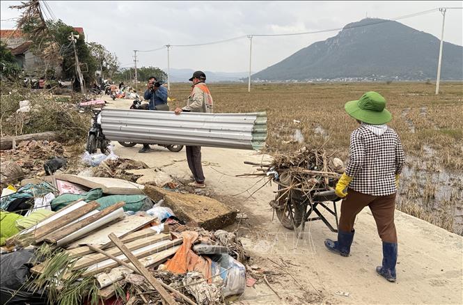 Người dân phường Tuy Hòa chung tay dọn vệ sinh đường làng, ngõ xóm sau mưa lũ. Ảnh: Tường Quân - TTXVN