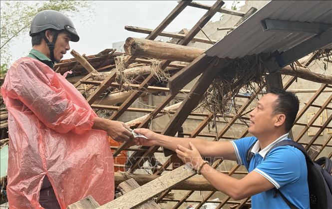 Anh Ngô Văn Chiêm (phường Tuy Hòa) có nhà bị sập hoàn toàn trong đợt mưa lũ vừa qua được hỗ trợ để vượt qua khó khăn. Ảnh: Tường Quân - TTXVN