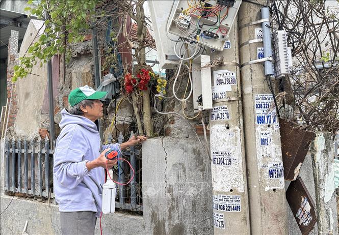 Một hộ dân tại phường Tuy Hòa sửa chữa hệ thống điện bị hư hỏng do mưa lũ. Ảnh: Tường Quân - TTXVN