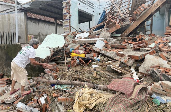 Ông Nguyễn Văn Tiến (khu phố Phước Khánh, phường Tuy Hòa) dọn dẹp nhà cửa bị sập do mưa lũ gây ra. Ảnh: Tường Quân - TTXVN