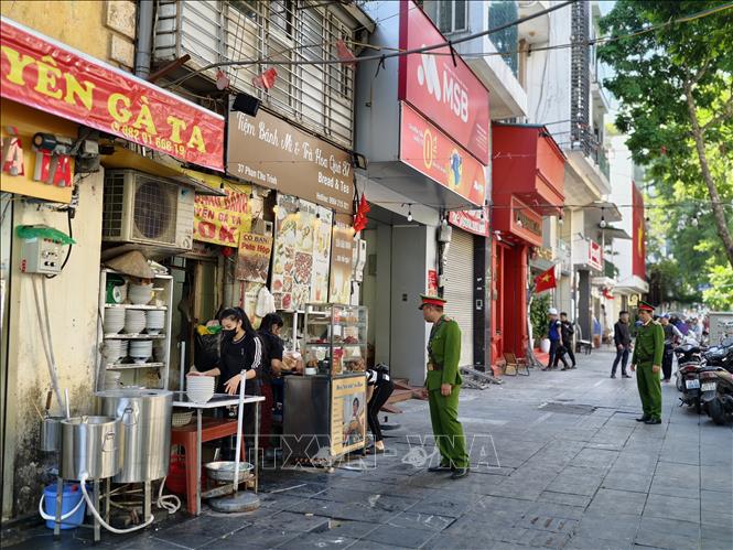 Tại phường Cửa Nam, Ban Chỉ đạo 197 phường nghiêm túc quán triệt; nhiều tổ công tác tỏa đi các “điểm nóng” xử lý vi phạm như lấn chiếm vỉa hè, lòng đường. Ảnh: Quốc Lũy - TTXVN