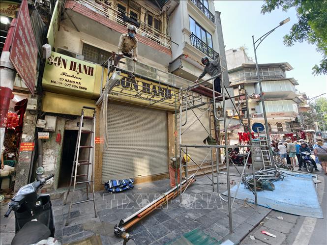 Công nhân tiến hành tháo dỡ mái hiên tại phố Hàng Mã, thực hiện nghiêm túc các quy định về trật tự đô thị trên địa bàn. Ảnh: Quốc Lũy - TTXVN