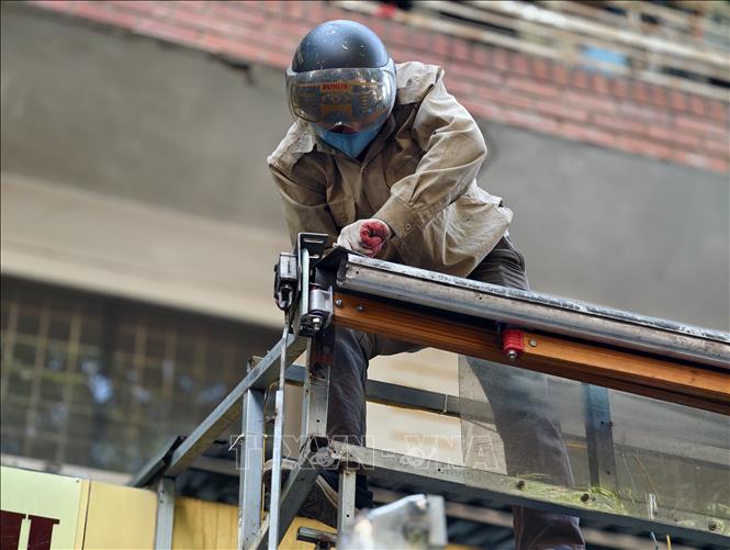 Công nhân tiến hành tháo dỡ mái hiên tại phố Hàng Mã, thực hiện nghiêm túc các quy định về trật tự đô thị trên địa bàn. Ảnh: Quốc Lũy - TTXVN