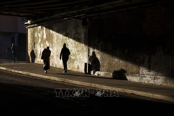 Người dân di chuyển trên đường phố tại Manchester, Anh, ngày 26/11/2025. Ảnh: THX/TTXVN