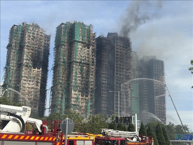 Ngọn lửa tại hiện trường vụ cháy cụm chung cư ở quận Tai Po vẫn chưa được dập tắt hoàn toàn vào chiều 27/11/2025. Ảnh: Mạc Luyện -PV TTXVN tại Hong Kong (Trung Quốc)