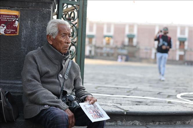 Một người cao tuổi hành nghề chụp ảnh tại thành phố di sản Puebla, miền Trung Mexico. Ảnh: Phi Hùng - PV TTXVN tại Mexico