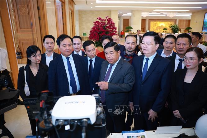 Phó Thủ tướng Nguyễn Chí Dũng và Phó Thủ tướng Mai Văn Chính tham quan trưng bày sản phẩm hỗ trợ sản xuất nông nghiệp. Ảnh: Dương Giang-TTXVN
