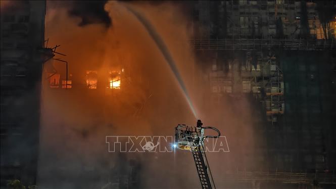 Lính cứu hỏa nỗ lực dập lửa tại hiện trường vụ cháy cụm tòa chung cư ở Tai Po, Hong Kong (Trung Quốc) ngày 26/11/2025. Ảnh: THX/TTXVN