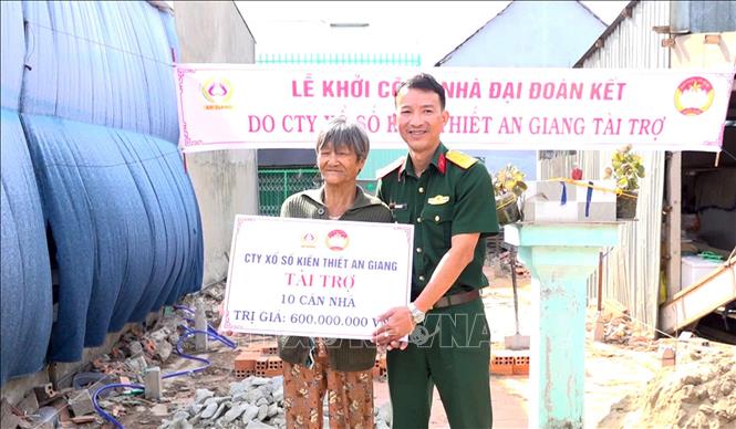 Bộ CHQS tỉnh An Giang trao bảng tượng trưng tài trợ xây dựng 10 căn nhà Đại đoàn kết cho người dân xã An Phú. Ảnh: TTXVN phát