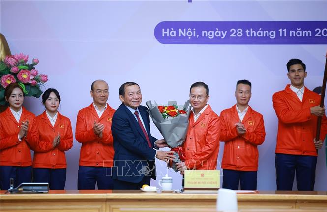 Bộ trưởng Bộ Văn hoá, Thể thao và Du lịch Nguyễn Văn Hùng tặng hoa chúc mừng cho  Đoàn thể thao Việt Nam tham dự SEA Games 33. Ảnh: Dương Giang-TTXVN
