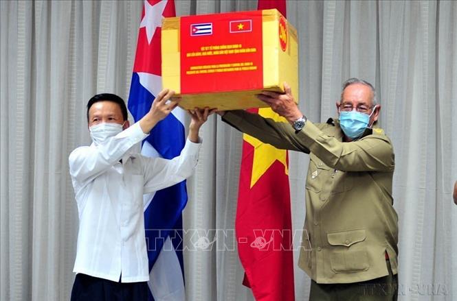Thượng tướng Ramón Espinosa Martín, Thứ trưởng Bộ Các lực lượng vũ trang Cuba và Đại biện Đại sứ quán Việt Nam tại Cuba Đỗ Đình Trường traotượng trưng viện trợ y tế của Việt Nam cho Cuba (La Habana, 30/7/2020). Ảnh: Vũ Lê Hà - TTXVN