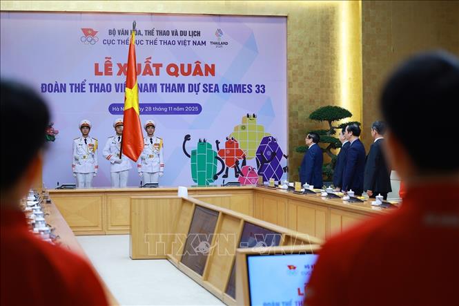 Thủ tướng Phạm Minh Chính và đại diện các vận động viên, huấn luyện viên đội tuyển quốc gia thực hiện nghi thức chào Cờ Tổ quốc. Ảnh: Dương Giang-TTXVN
