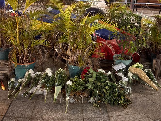 Người dân đặt hoa tưởng niệm các nạn nhân của vụ cháy chung ở khu tổ hợp Wang Fuk Court.  Ảnh: Mạc Luyện PV TTXVN tại Hong Kong