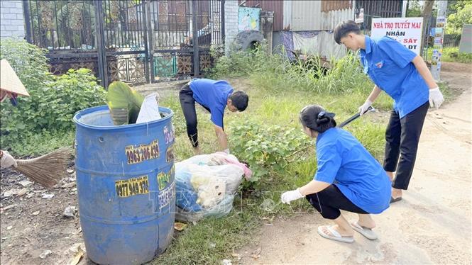 Lực lượng thanh niên tình nguyện dọn dẹp vệ sinh chung. Ảnh: Nhật Bình – TTXVN.