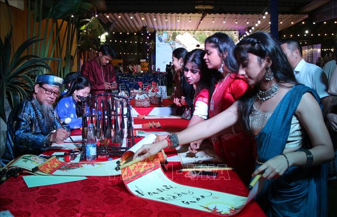 Bạn bè quốc tế tham quan khu vực tặng tranh chữ thư pháp. Ảnh: Nguyễn Hằng - TTXVN