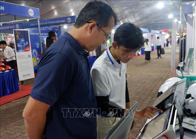 Khách hàng tiếp cận các công cụ chuyển đổi số. Ảnh: Đức Hạnh - TTXVN 