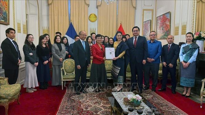 Phu nhân Đại sứ Lào tại Pháp trao quà lưu niệm tặng phu nhân Đại sứ Việt Nam tại Pháp nhân dịp chuẩn bị kết thúc nhiệm kỳ. Ảnh: Hữu Chiến - P/v TTXVN tại Pháp