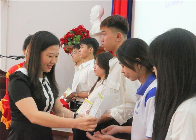 Chị Hồ Thị Hồng Phướng trao học bổng cho các em học sinh, sinh viên nghèo hiếu học. Ảnh: Công Mạo - TTXVN