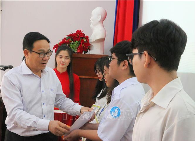 Ông Ngô Vũ Hải, Phó Giám đốc Công ty TNHH MTV Xổ số kiến thiết An Giang trao học bổng cho các em học sinh, sinh viên nghèo hiếu học. Ảnh: Công Mạo - TTXVN