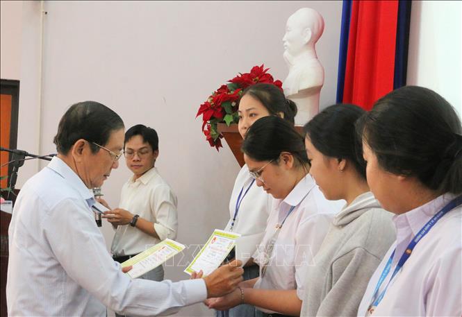 Ông Nguyễn Đăng Giai, Phó Chủ tịch Thường trực Hội Khuyến học tỉnh An Giang trao học bổng cho các em học sinh, sinh viên nghèo hiếu học. Ảnh: Công Mạo - TTXVN