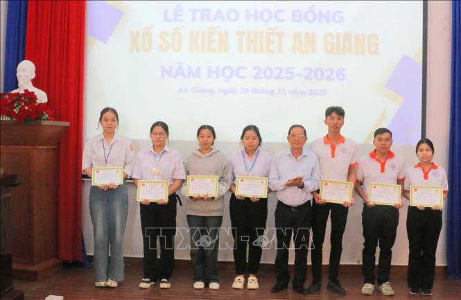 Ông Nguyễn Đăng Giai, Phó Chủ tịch Thường trực Hội Khuyến học tỉnh An Giang trao học bổng cho các em học sinh, sinh viên nghèo hiếu học. Ảnh: Công Mạo - TTXVN