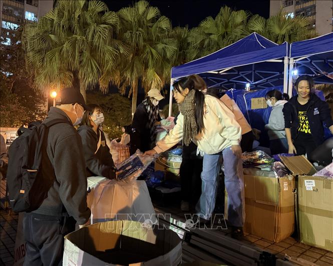 Người dân nhận các nhu yếu phẩm tại các trạm phát quần áo, thực phẩm. Ảnh: Mạc Luyện PV TTXVN tại Hong Kong