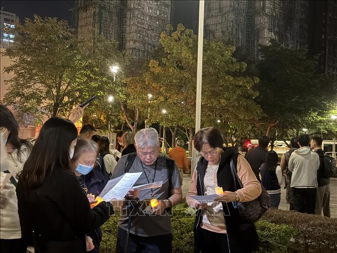 Người dân đốt nến nguyện cầu cho các nạn nhân xấu số trong vụ hỏa thoạn. Ảnh: Mạc Luyện PV TTXVN tại Hong Kong