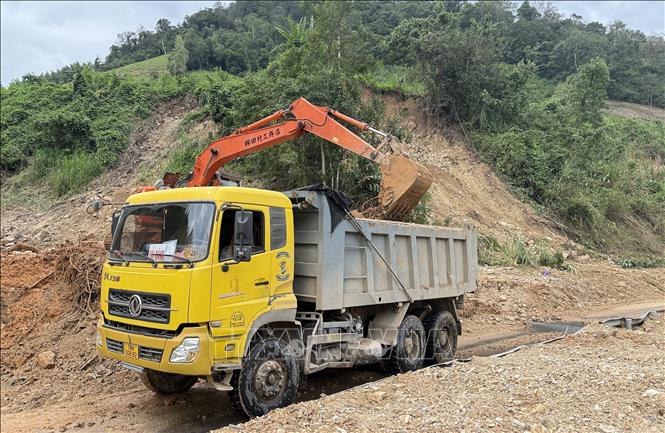 Các đơn vị trong tỉnh Đắk Lắk khẩn trương khơi thông tuyến đường bị sạt lở do mưa lũ gây ra. Ảnh: Tường Quân – TTXVN 