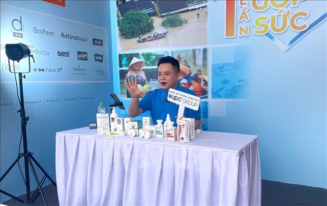 Người sáng tạo nội dung số đang thực hiện livestream quảng bá sản phẩm và bán hàng tại sự kiện. Ảnh: Thu Hương - TTXVN