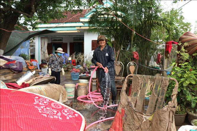 Người dân xã Tuy An Tây dọn dẹp nhà cửa sau mưa lũ nhằm sớm ổn định đời sống. Ảnh: Tuấn Anh - TTXVN