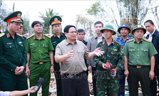 Thủ tướng Phạm Minh Chính thăm vùng ngập nước hoàn toàn tại thôn Phú Hữu, xã Hòa Thịnh và nghe báo cáo về phương án xây dựng nhà tránh lũ cho bà con, nhân dân vùng lũ. Ảnh: Dương Giang-TTXVN 
