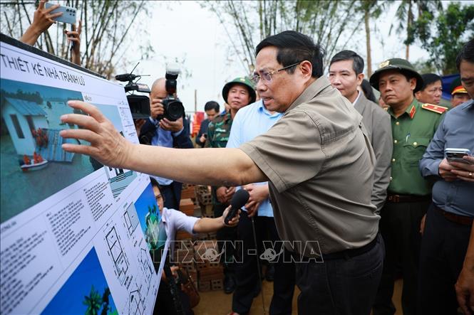 Thủ tướng Phạm Minh Chính xem phương án xây dựng nhà tránh lũ cho bà con, nhân dân vùng lũ. Ảnh: Dương Giang-TTXVN 