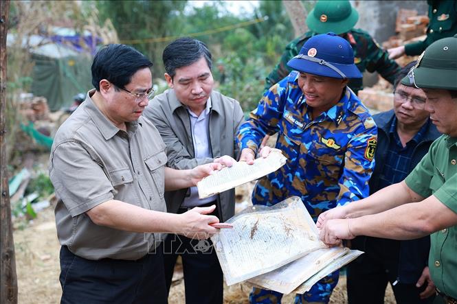 Thủ tướng Phạm Minh Chính thăm hộ gia đình có nhà bị sập hoàn toàn tại thôn Phú Hữu, xã Hòa Thịnh. Ảnh: Dương Giang-TTXVN
