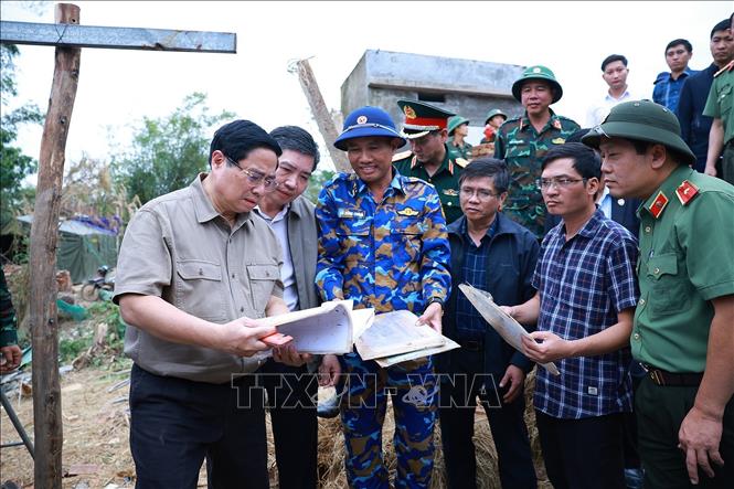 Thủ tướng Phạm Minh Chính thăm hộ gia đình có nhà bị sập hoàn toàn tại thôn Phú Hữu, xã Hòa Thịnh. Ảnh: Dương Giang-TTXVN
