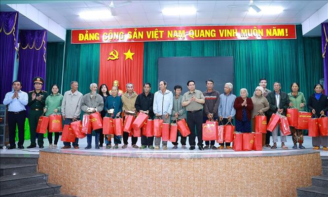 Thủ tướng Phạm Minh Chính tặng quà động viên hộ gia đình có nhà bị sập hoàn toàn do mưa lũ tại thôn Phú Hữu, xã Hòa Thịnh. Ảnh: Dương Giang-TTXVN 
