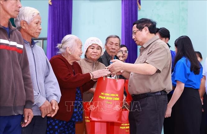 Thủ tướng Phạm Minh Chính tặng quà động viên hộ gia đình có nhà bị sập hoàn toàn do mưa lũ tại thôn Phú Hữu, xã Hòa Thịnh. Ảnh: Dương Giang-TTXVN 
