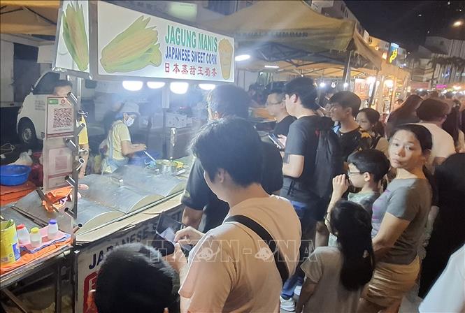 Khách xếp hàng tại một quầy bán đồ ăn ở chợ đêm Taman Segar. Ảnh: Bùi Hoàn - TTXVN