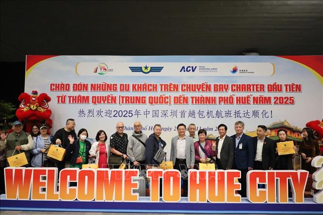 Các hành khách trên chuyến bay DZ6355  được lãnh đạo UBND thành phố Huế trao hoa và tặng quà lưu niệm chúc mừng. Ảnh: Văn Dũng-TTXVN
