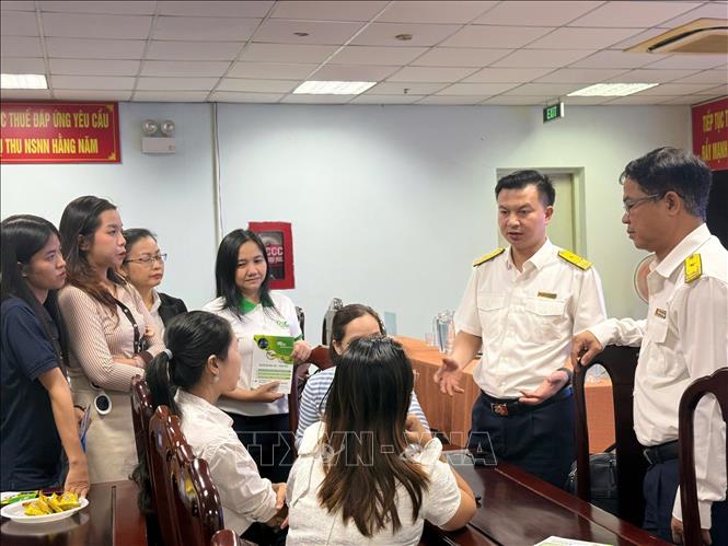 Lãnh đạo Thuế TP. Hồ Chí Minh giải đáp các vướng mắc cho các hộ kinh doanh về mô hình quản lý thuế theo phương pháp kê khai. Ảnh: Hứa Chung-TTXVN