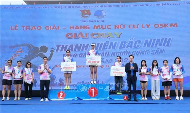 Ban Tổ chức trao giải cho các vận động viên xuất sắc nội dung nữ 5 km. Ảnh: Đồng Thúy-TTXVN