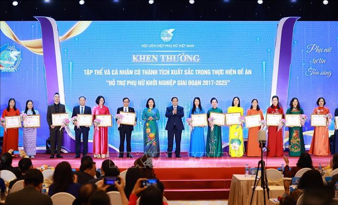 Thủ tướng Phạm Minh Chính trao bằng khen của Hội Liên hiệp Phụ nữ Việt Nam cho điển hình triển khai Đề án 939. Ảnh: Dương Giang-TTXVN 
