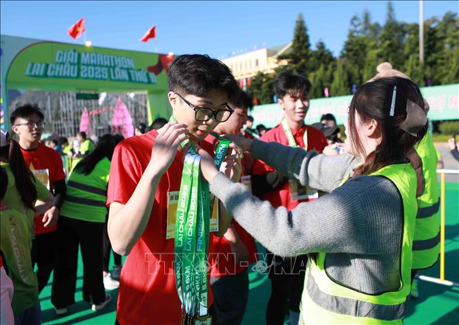 Ban tổ chức trao huy chương cho các vận động viên hoàn thành các cự ly. Ảnh: Quý Trung – TTXVN