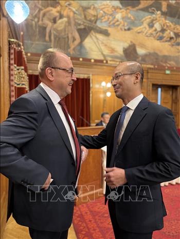 Đại sứ Việt Nam tại Hungaria Bùi Lê Thái trao đổi với một đại biểu tại Diễn đàn. Ảnh: TTXVN phát