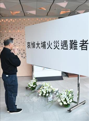 Người dân đặt hoa tưởng niệm các nạn nhân thiệt mạng trong vụ hỏa hoạn tại khu tổ hợp chung cư Wang Fuk Court ở quận Tai Po, Hong Kong (Trung Quốc), ngày 30/11/2025. Ảnh: Yonhap/TTXVN