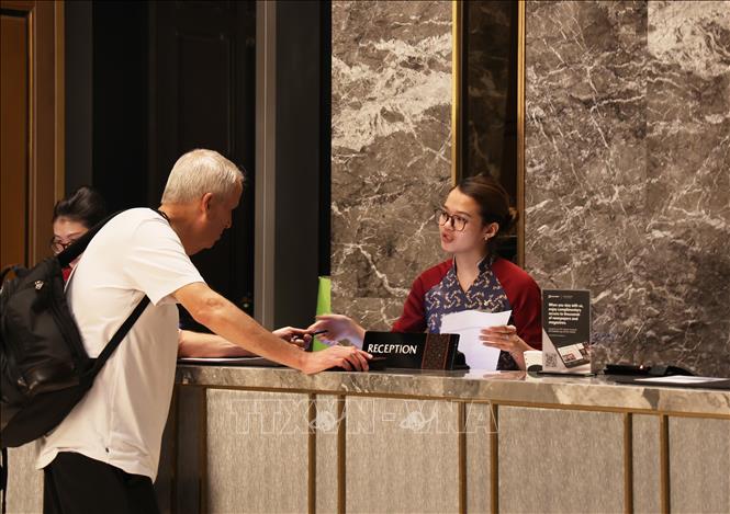 Nhân viên lễ tân khách sạn Vinpearl Landmark 81, Autograph Collection hướng dẫn khách quốc tế làm thủ tục lưu trú. Ảnh: Hồng Đạt - TTXVN